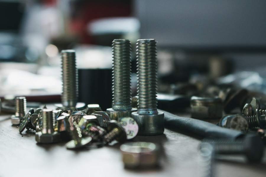 Steel bolts, nuts and fasteners on a workbench